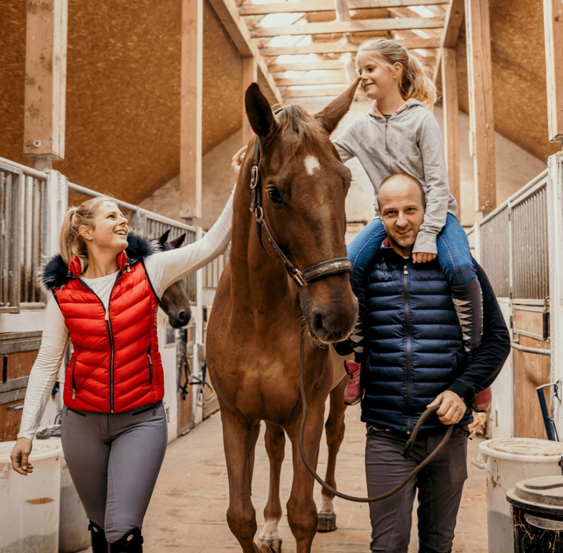 Family with a horse in a stable