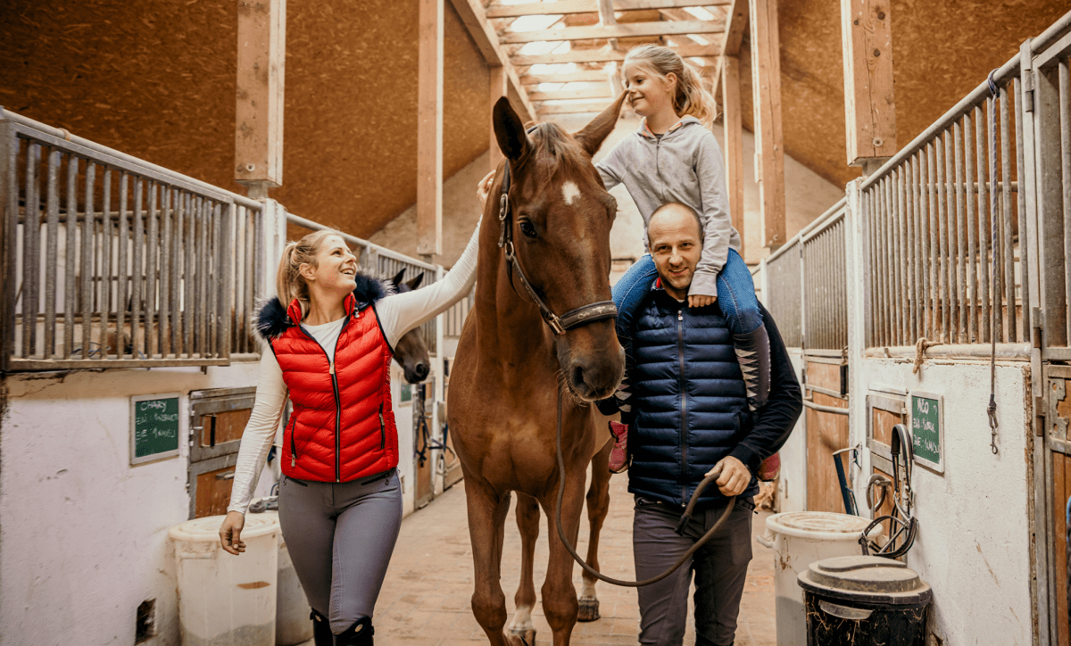 Family with a horse in a stable