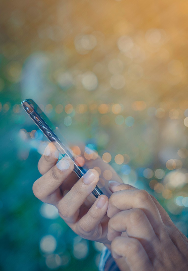 Mains d'une personne tenant un smartphone